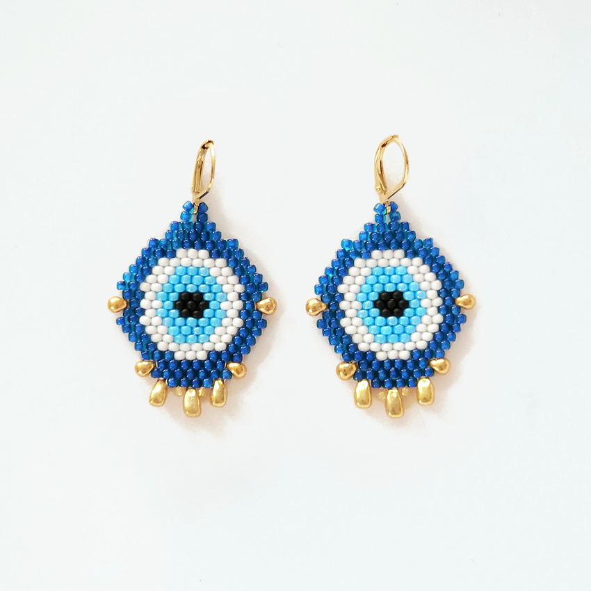 Blue and white beaded earrings with gold accents on a white background