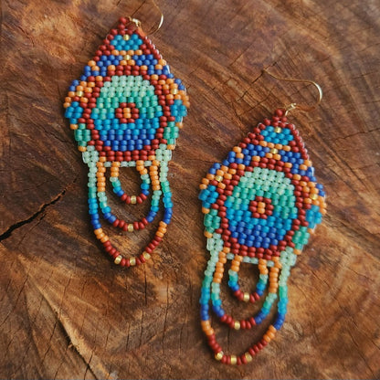 Colorful beaded earrings on a wooden surface