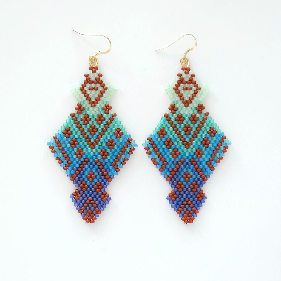 Pair of beaded earrings with geometric pattern on a white background