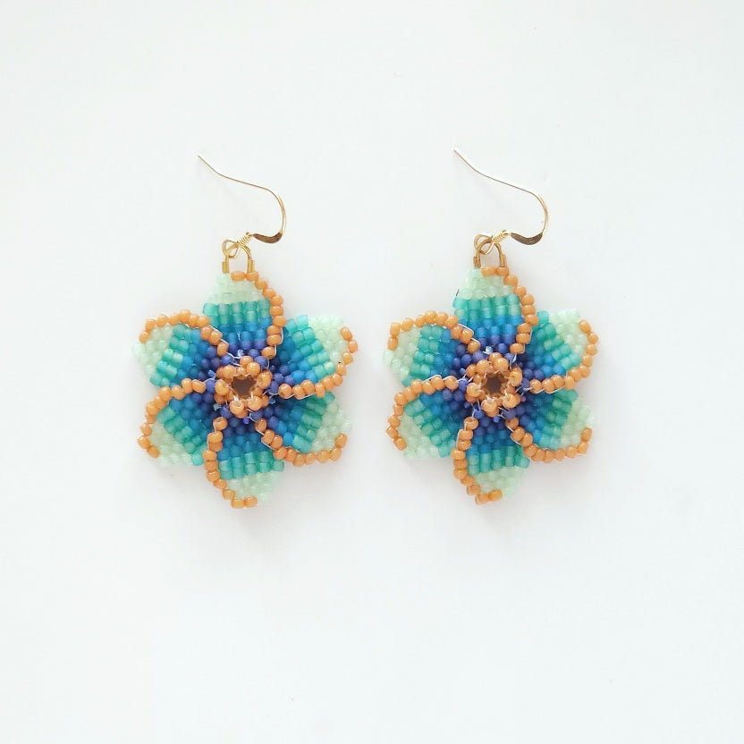 Pair of Blue Tropical beaded flower earrings on a white background