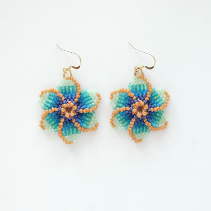 Pair of Blue Tropical beaded flower earrings on a white background