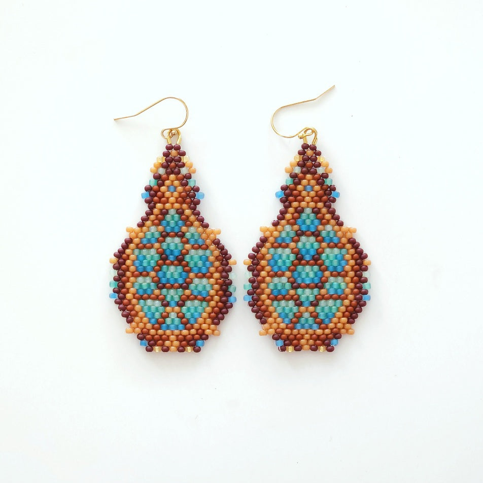 Pair of beaded turtle earrings on a white background