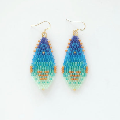 Pair of beaded earrings with blue, green, and orange gradient on a white background