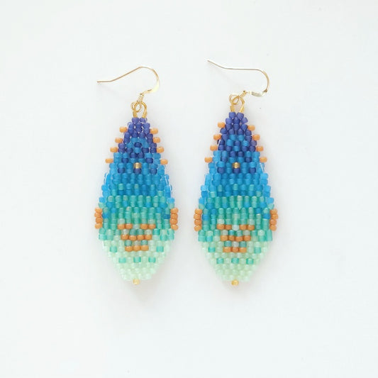 Pair of beaded earrings with blue, green, and orange gradient on a white background